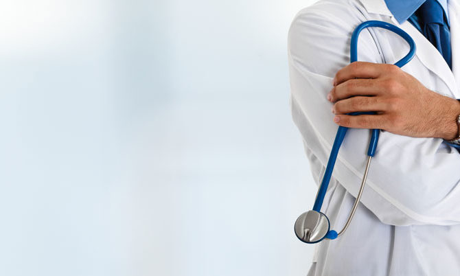 Doktor sa doktorskim slušalicama u beloj medicinskoj uniformi